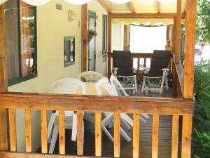 una terraza con sillas blancas y una mesa en Mobile home / Chalet Viareggio - Camping Paradiso Toscane en Viareggio