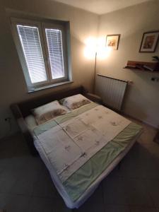 ein kleines Bett in einem Zimmer mit Fenster in der Unterkunft Apartma Laura in Ankaran