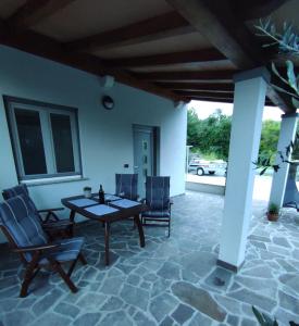 a patio with a table and chairs on a patio at Apartma Laura in Ankaran