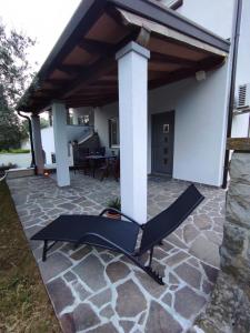 a patio with awning and a hammock under a house at Apartma Laura in Ankaran