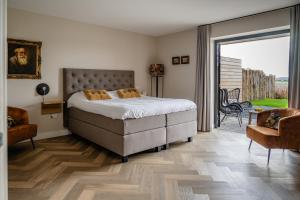 a bedroom with a bed and a sliding glass door at B&B de Cley in Noordwijk