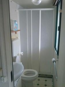 bagno bianco con servizi igienici e lavandino di Mobile home / Chalet Viareggio - Camping Paradiso Toscane a Viareggio
