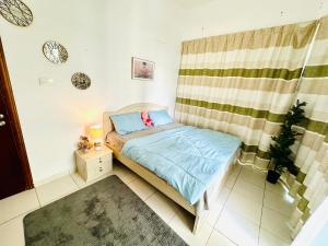 a small bedroom with a bed and a curtain at Deluxe GIRLS HOSTEL in Dubai