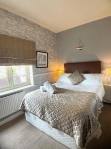 um quarto com uma cama grande e uma parede de tijolos em The Lawns Hotel em Derby