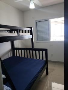 a bunk bed in a room with a window at Apartamento confortável no Centro in Bertioga