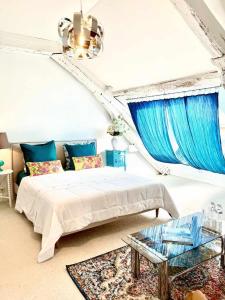 um quarto com uma cama e cortinas azuis em Maison B em Bergerac