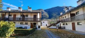 a group of buildings with mountains in the background at Appartamento Lidia piano terra in Santa Maria Maggiore