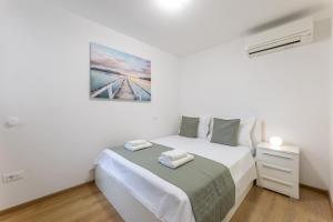 - une chambre blanche avec un lit et une table de chevet dans l'établissement Apartment ALEX in Kaštel Novi, à Kaštela