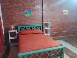 a bedroom with a bed and a brick wall at Descanso Cordillerano in San Rafael