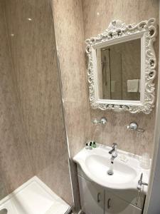 a bathroom with a sink and a mirror at The Lawns Hotel in Derby