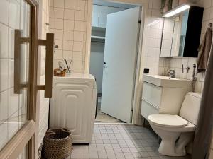 a white bathroom with a toilet and a sink at Central 2 Br in Tampere