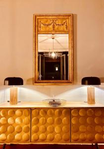 モンペリエにあるCasa Roma Montpellier Bed&Breakfast chambres d hôteの燭台付き化粧台の上の壁面鏡