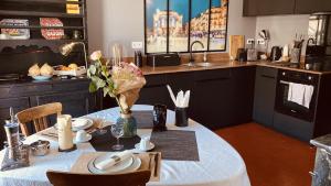 een keuken met een tafel met een witte tafeldoek bij Casa Roma Montpellier Bed&Breakfast chambres d hôte in Montpellier