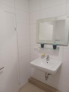 Gmunden zentrale Lage في غموندين: حمام أبيض مع حوض ومرآة