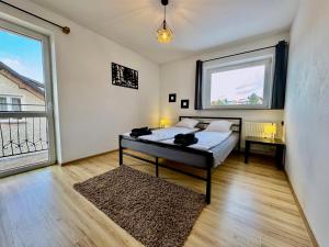 um quarto com uma cama e uma grande janela em Domek Monte Black z jacuzzi i sauną fińską em Stronie Śląskie