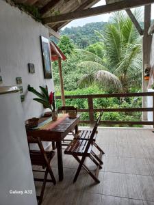 cocina con mesa y sillas y balcón en Pousadinha Ateliê da Maite, en Paraty