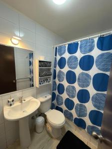 ein Badezimmer mit einem WC, einem Waschbecken und einem Spiegel in der Unterkunft Amplia Casa en Condominio in La Serena