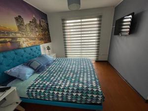 ein Schlafzimmer mit einem großen Bett und einem Fenster in der Unterkunft Amplia Casa en Condominio in La Serena