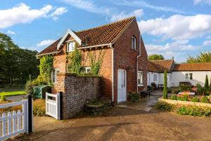 a brick house with a white fence at Harvest Cottage in Bridlington