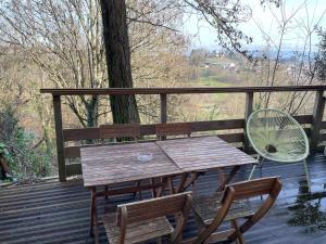 a wooden table and two chairs on a deck at Chez Gabriel et Sophie in Pérouges