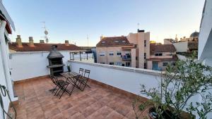 - un balcon avec 2 chaises et une cloche dans un bâtiment dans l'établissement El Alce del Pilar ComoTuCasa, à Huesca