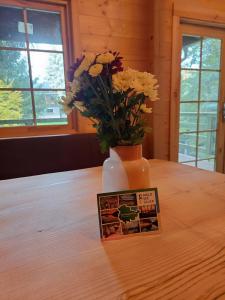 um vaso com flores sobre uma mesa com uma imagem em Tiny House am Teich em Garnsdorf