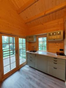 uma cozinha com uma grande ilha num camarote com janelas em Tiny House am Teich em Garnsdorf