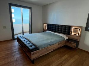 - une chambre avec un grand lit et une grande fenêtre dans l'établissement Appartement Ocean View - Marina Casablanca, à Casablanca