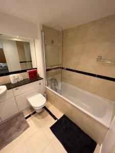 ein Badezimmer mit einem WC, einer Badewanne und einem Waschbecken in der Unterkunft Ensuite Room in Royal Victoria Excel O2 Arena London in London