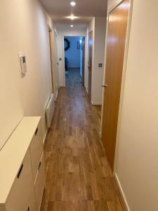 a hallway of an apartment with wooden floors at Ensuite Room in Royal Victoria Excel O2 Arena London in London