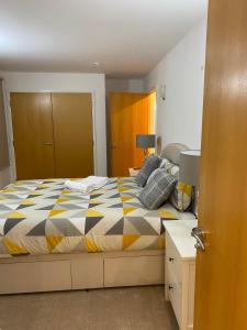 een slaapkamer met een bed met een kleurrijk dekbed bij Ensuite Room in Royal Victoria Excel O2 Arena London in Londen