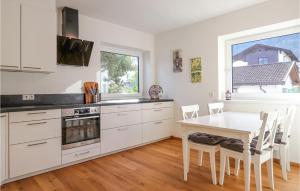 a kitchen with white cabinets and a table and chairs at Awesome Apartment In Axams With Kitchen in Innsbruck