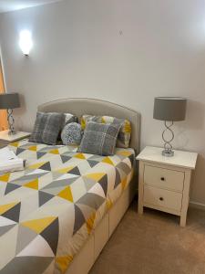a bedroom with a bed and a nightstand with two lamps at Ensuite Room in Royal Victoria Excel O2 Arena London in London
