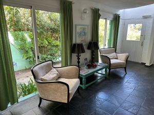 a living room with two chairs and a table at Hotel Butique Donatella Mare. in Punta del Este