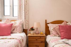 a bedroom with two beds and a table with a lamp at Harvest Cottage in Bridlington