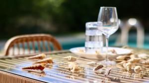 - une table avec un verre de vin et une assiette de nourriture dans l'établissement Mediterranean Luxury Villa, à Ialyssos