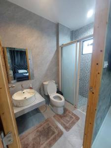 uma casa de banho com um WC, um lavatório e um chuveiro em Baan Pak Arom Resort Chanthaburi 