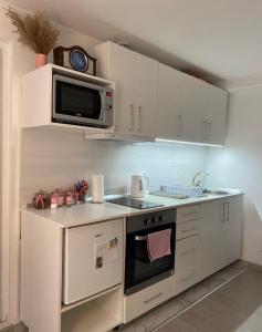 uma cozinha com armários brancos e um micro-ondas em Fairytale Apartment em Sarajevo