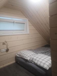 ein kleines Bett in einem Zimmer mit Fenster in der Unterkunft Verknės slėnis in Aukštadvaris