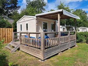 a wooden house with a gazebo on a yard at Tiny house in Wittelte