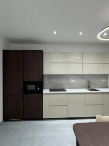 uma cozinha com armários brancos e um micro-ondas preto em NEW Modern Large Apartment in New Town 3BDR em Praga