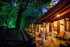 a house with a lit up backyard at night at Colonial Residence Kandy Villa in Kandy