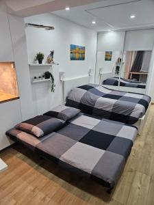 two beds in a room with a mirror at Lovely appartement near sea and Monaco with free parking in Roquebrune-Cap-Martin