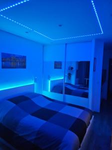 a bedroom with a bed with blue lights on it at Lovely appartement near sea and Monaco with free parking in Roquebrune-Cap-Martin