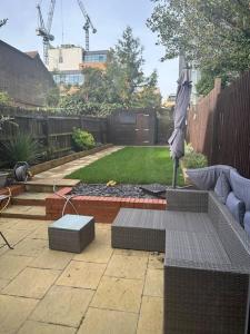 a patio with an umbrella and a fire pit at Adam’s Place, Watford WD17 2PY (near Harry Potter) in Watford