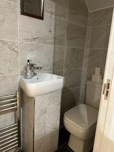 a bathroom with a sink and a toilet at Adam’s Place, Watford WD17 2PY (near Harry Potter) in Watford