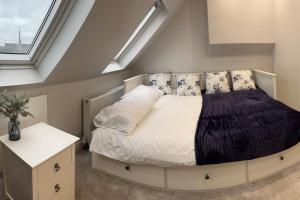um quarto com uma cama grande com almofadas em Adam’s Place, Watford WD17 2PY (near Harry Potter) em Watford