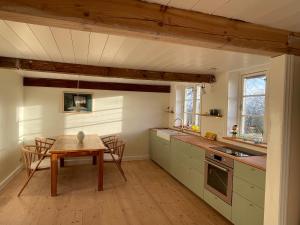 a kitchen with a wooden table and a table and chairs at Wildernest Bornholm in Neksø