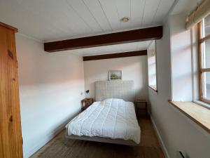 a bedroom with a bed in a room with windows at Wildernest Bornholm in Neksø
