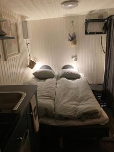 una camera con un letto con cuscini sopra di Mysigt och lugnt på landet a Blentarp